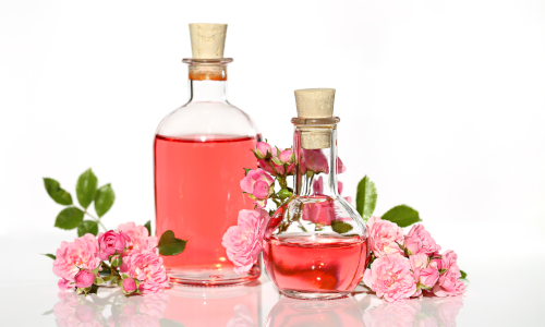 Bottiglie di aroma circondate da rose