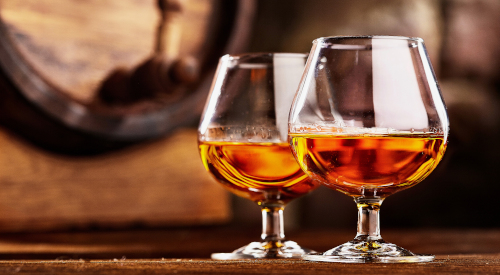 Bicchieri di cognac davanti a una botte
