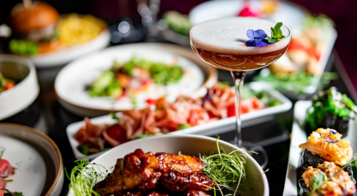 A cocktail surrounded by refined dishes