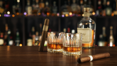 2 verres à whisky old fashioned posés sur un bar