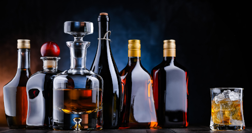 Botellas de licores y un vaso de whisky