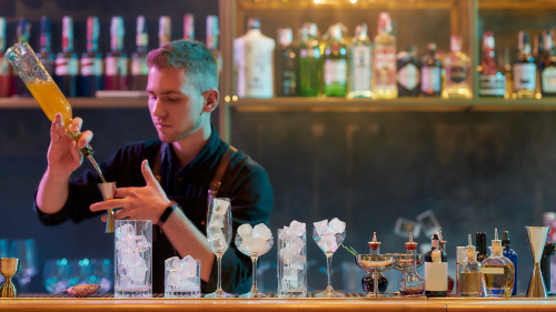 Un barman réalise une recette de cocktail