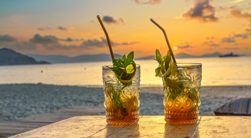 Mojito glasses on the beach at sunset