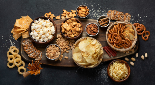 Chips, snack biscuits, and dried fruits arranged on a tray