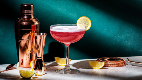 Cocktail posé sur une table avec des ustensiles de bar