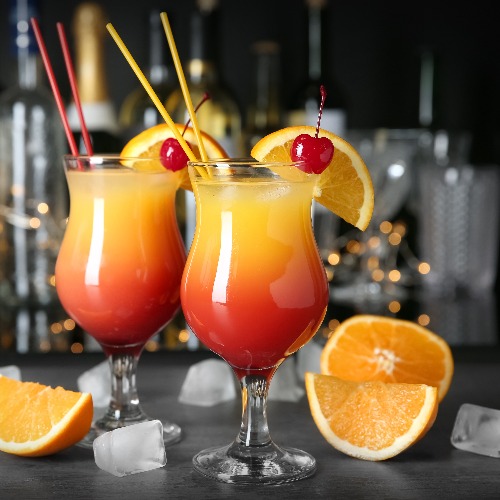 <p>A bar counter is adorned with Sex on the Beach cocktail glasses.</p>