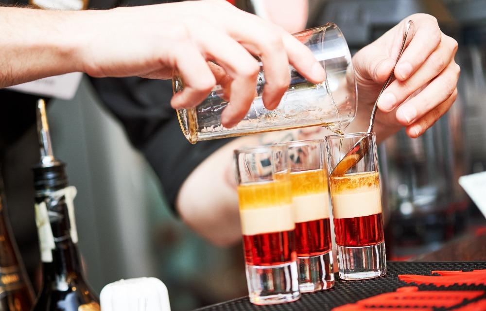 verre de shooter contenant cocktail de differente couche de couleur superposée